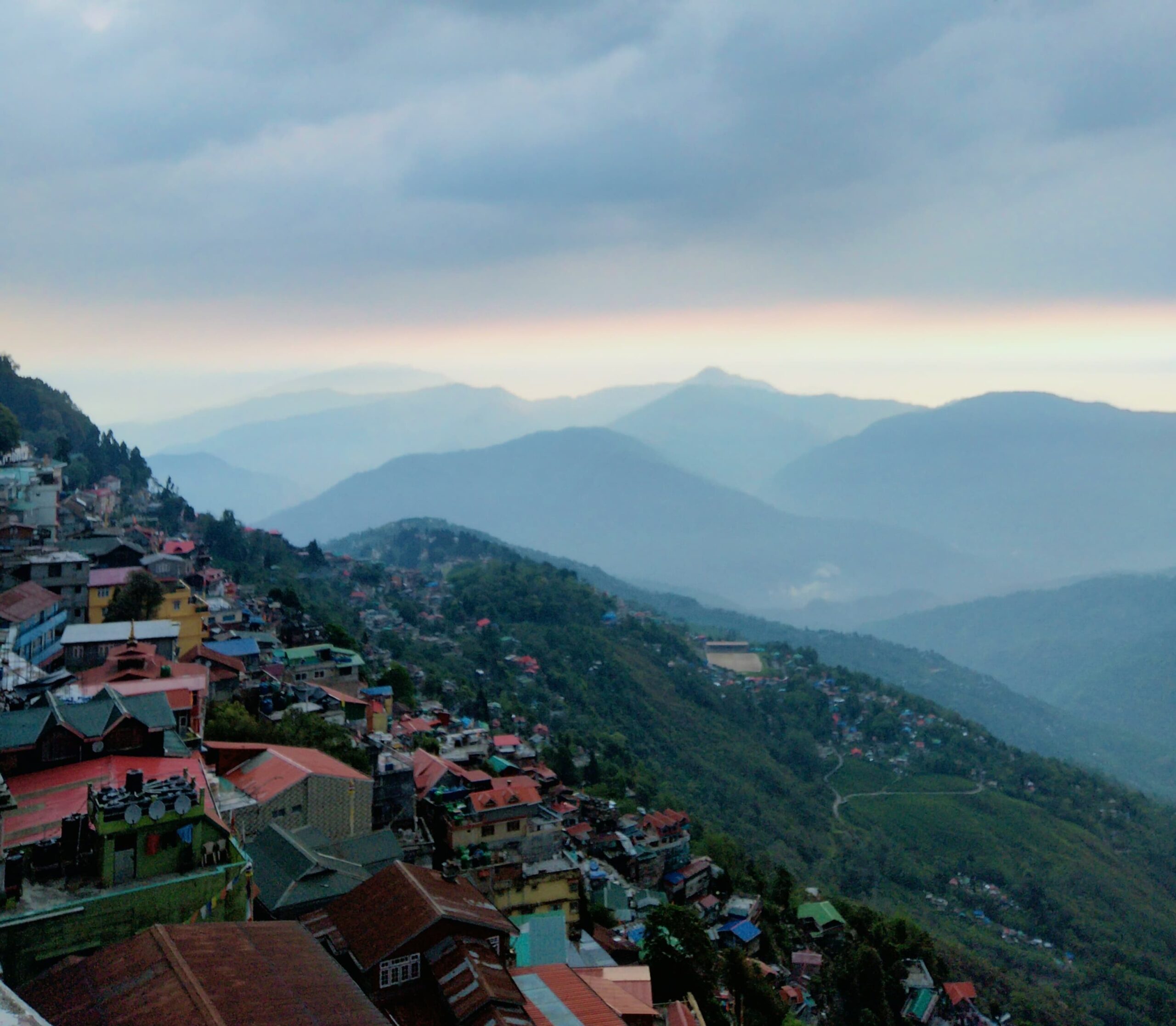 Darjeeling, Hilltop city view with majestic mountains in background.